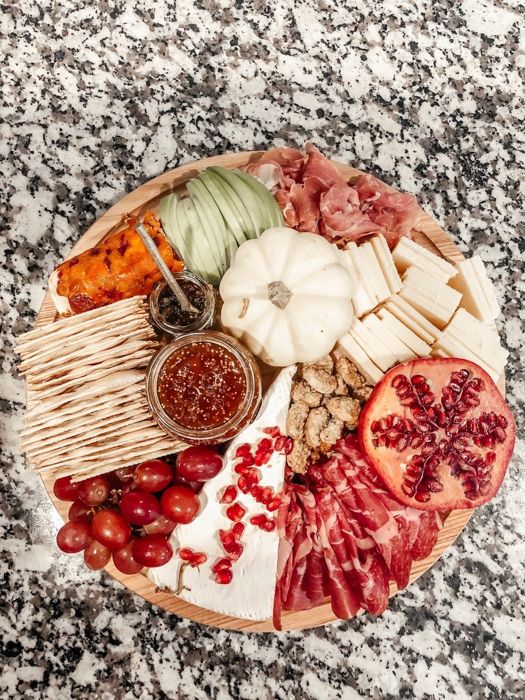 Charcuterie board with a jar of RedGold in the center