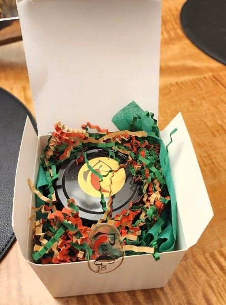 A jar of RedGold in red and green crinkle in an open white gift box