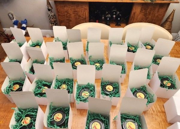 A table full of RedGold gift boxes packed with green crinkle