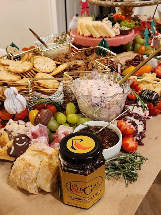 A grazing board with a jar of RedGold among cheeses and crackers
